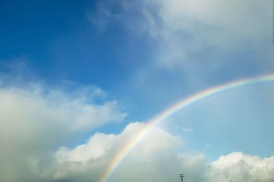 Low angle view of rainbow against blue sky