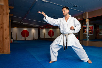 Karate man stand your ground on tatami doing "shuto uchi"