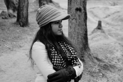 Young woman looking away on tree trunk