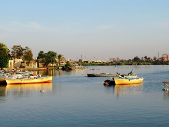 Boats moored in river against sky