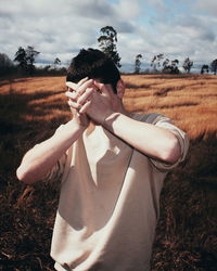 Midsection of man standing on field against sky