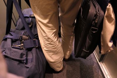 Low section of man with luggage in train