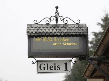 Low angle view of information sign against sky