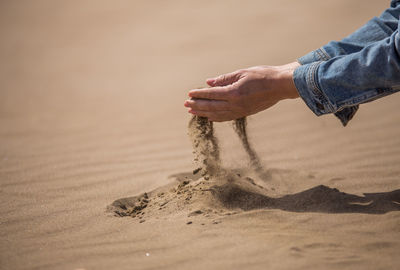 Midsection of man on sand at beach