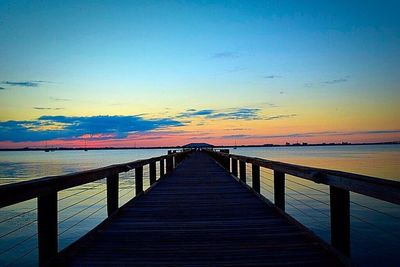 Pier on sea at sunset