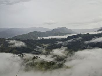 Scenic view of mountains against cloudy sky