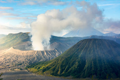 Smoke emitting from volcanic mountain against sky