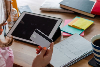 High angle view of woman using mobile phone on table