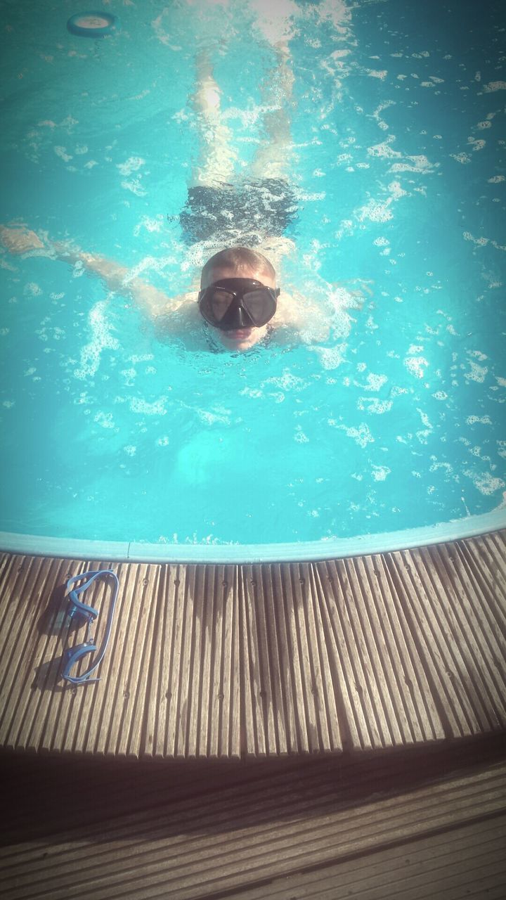 HIGH ANGLE VIEW OF MAN IN SWIMMING POOL