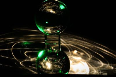 Close-up of illuminated light bulb against black background