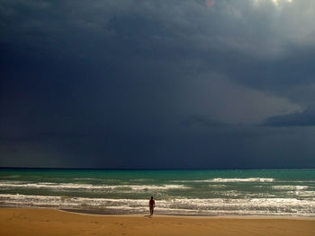 Man standing on beach against sky