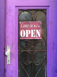 Close-up of open sign on closed door