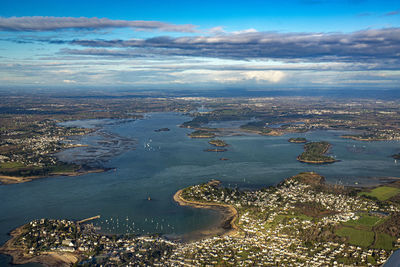 High angle view of cityscape by sea against sky