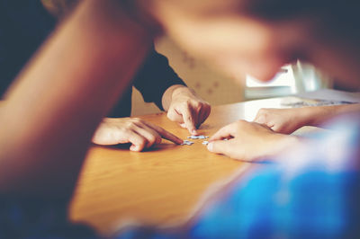 Close-up of woman hand holding paper with text on table