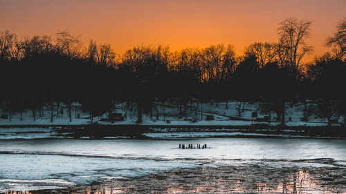 Scenic view of lake against orange sky