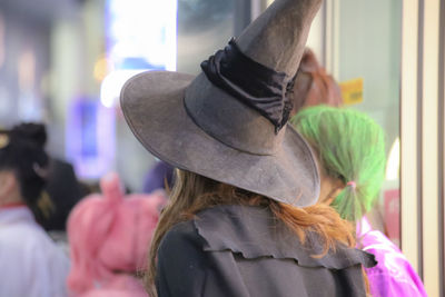 Rear view of woman wearing witch hat during halloween