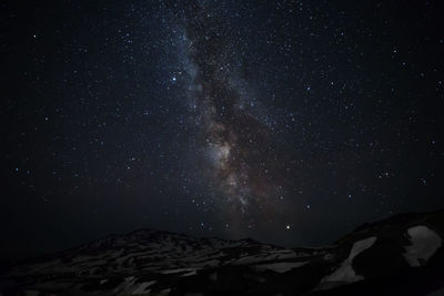 Scenic view of mountains against star field at night