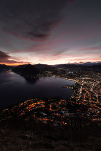 High angle view of illuminated cityscape against sky during sunset