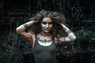 Portrait of young woman standing in forest