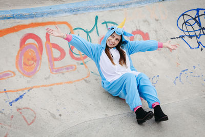 Full length of woman with graffiti on wall