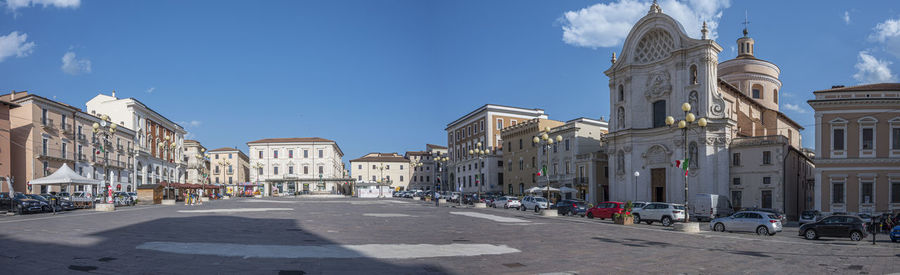 Extra wide angle view of the beautiful piazza duomo in l'aquila with historic buildings and churches