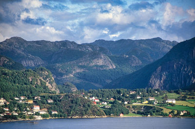 Scenic view of townscape by mountains against sky