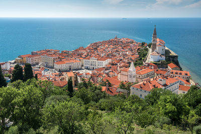 High angle view of townscape by sea against sky