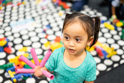 High angle view of cute girl with toys on fingers