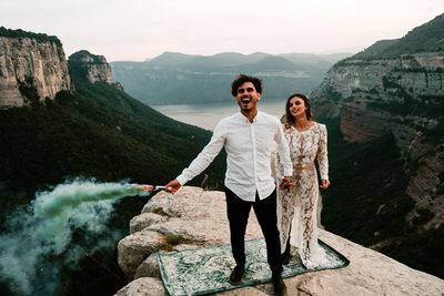 Portrait of happy friends standing on rock