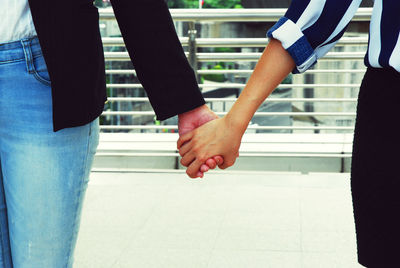 Midsection of couple holding hands