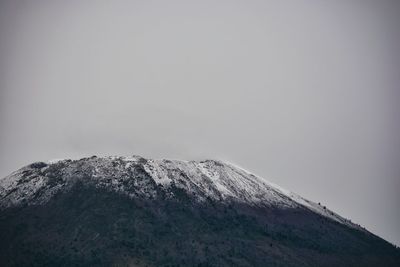 Low angle view of snowcapped mountain against sky