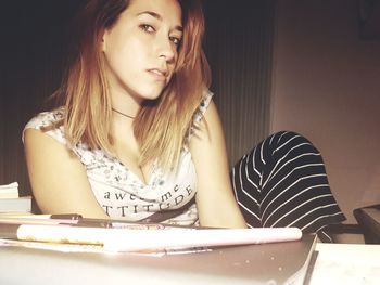 Close-up of young woman sitting on table