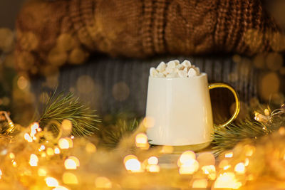 Cup of hot chocolate with marshmallow, knitted sweaters, garland light. christmas, xmas