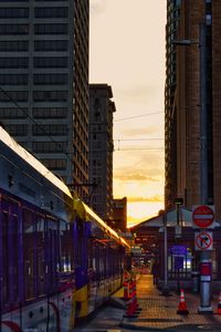 Illuminated city against sky at sunset