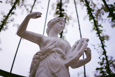 Statue of an angel holding small harp in the garden