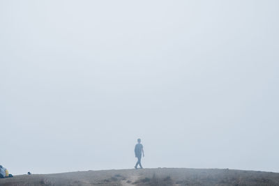 Full length of man standing against clear sky