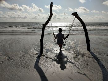 A woman playing swing on the beach