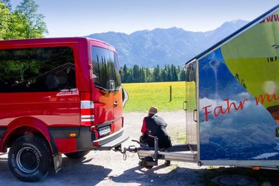 Rear view of man sitting on seat against mountain