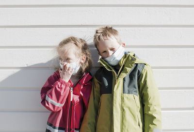 Siblings wearing medical masks to protect from corona virus