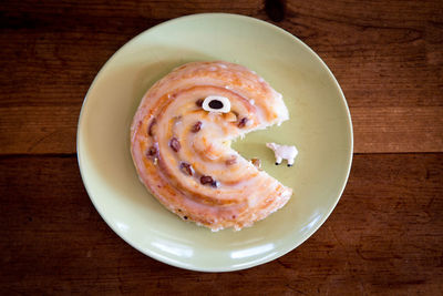 High angle view of cake served in plate on wooden table