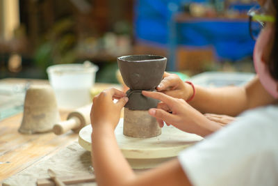 Girl making pot on pottery wheel