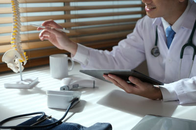 Midsection of doctor examining patient in clinic