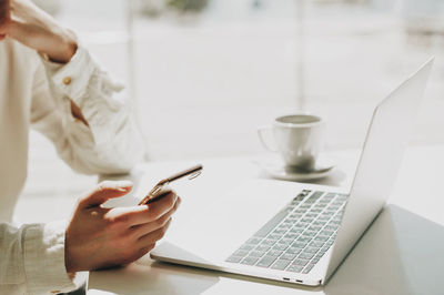 Close-up of person using laptop on table