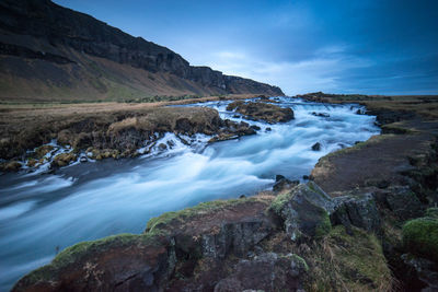 Scenic view of waterfall against sky