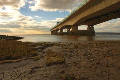 View of bridge over river against cloudy sky