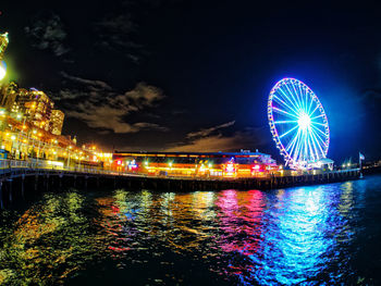 Illuminated ferris wheel at night