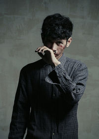 Portrait of injured young man standing against wall