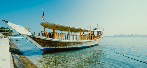 Ship moored in sea against clear sky