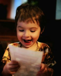 Close-up of happy girl reading greeting card