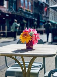Pink flower on sidewalk cafe by street